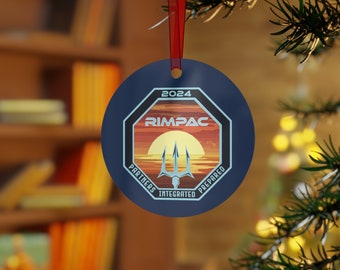 May include: A blue round Christmas ornament with a white octagon shape in the center. The octagon has a sunset scene with a trident and the text "2024 RIMPAC PARTNERS INTEGRATED PREPARED".