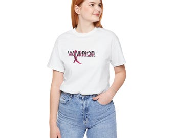 May include: White t-shirt with a pink ribbon and the word "WARRIOR" printed on the front.