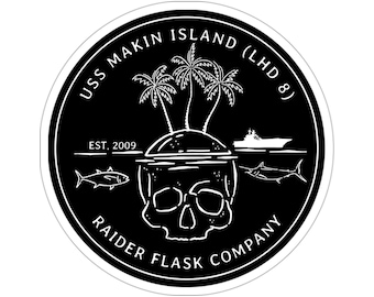 May include: Black and white circular sticker with the text "USS MAKIN ISLAND (LHD 8)" and "RAIDER FLASK COMPANY". The sticker also features a skull with a tropical island and palm trees inside the skull. The text "EST. 2009" is also included.