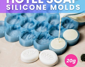 May include: Blue silicone mold with 20 individual round cavities for making hotel soap bars. The mold is filled with white soap and a pitcher pours more white soap into the mold. A finished soap bar is shown next to the mold. The text "20g" is visible in the image.