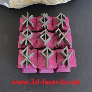 Könnte beinhalten: Zwölf kleine, quadratische, rosafarbene Keycaps mit schwarzen, erhabenen, geometrischen Symbolen. Die Symbole sind nordische Runen. Die Keycaps sind in einem 3x4-Raster angeordnet. Der Text "www.3d-laser-bu.de" ist unter den Keycaps gedruckt.