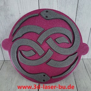 Könnte beinhalten: Eine runde, pinkfarbene, glitzernde Plakette mit einem grauen Unendlichkeits-Symbol-Design. Das Symbol besteht aus zwei ineinander verschlungenen Schlangen, deren Köpfe sich am unteren Rand der Plakette befinden. Die Plakette trägt unten eine Website-Adresse: www.3d-laser-bu.de.