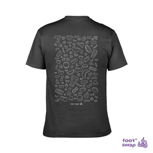 May include: Dark gray t-shirt featuring a white outline design of climbing holds. The back of the shirt displays a pattern of various shapes and sizes of climbing holds. The text "foot swap" is printed at the bottom.