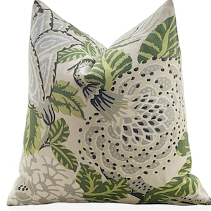 May include: A decorative throw pillow with a floral pattern in shades of green, gray, and white. The pillow features a large, stylized floral design with intricate details.