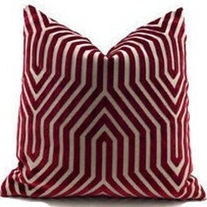 May include: A decorative pillow with a geometric pattern in shades of burgundy and white.
