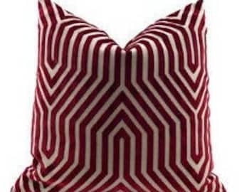 May include: A decorative pillow with a geometric pattern in shades of burgundy and white.