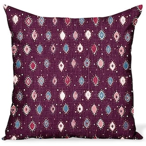 May include: A square throw pillow with a deep purple base color featuring a repeating pattern of small diamond shapes in shades of light blue, dusty pink, and white, accented by tiny white dots scattered across the textured fabric surface.