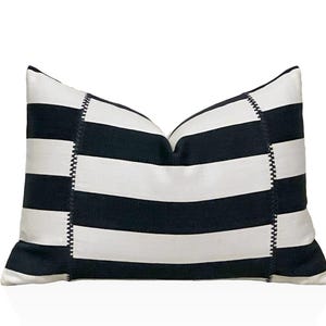May include: Black and white striped cushion with a decorative stitched border.