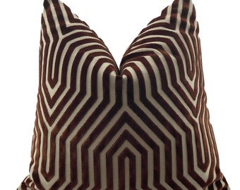 May include: A decorative throw pillow with a geometric pattern. The pillow features a repeating design of brown and cream-colored lines, creating a striking visual effect. The pillow is a square shape and appears to be made of a soft, textured fabric.