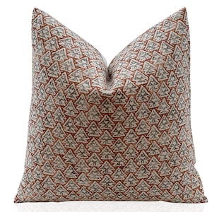 May include: A decorative throw pillow with a white background and a repeating pattern of brown and gray stylized Christmas trees.