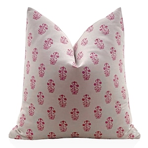 May include: A white pillow with a pink floral pattern. The pillow is made of a soft, comfortable fabric and has a subtle sheen.