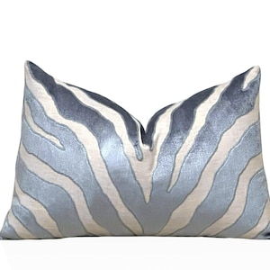 May include: A decorative cushion with a blue and white zebra print pattern. The cushion is made of a soft, plush fabric.