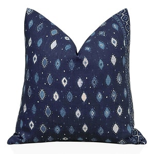 May include: A blue and white patterned throw pillow with a diamond pattern. The pillow is made of a soft, textured fabric.