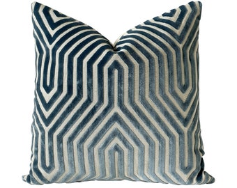 May include: A blue and white geometric patterned throw pillow with a soft, plush velvet texture.