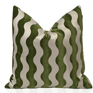 May include: A green and white striped throw pillow with a wavy pattern. The pillow is made of velvet and has a soft, luxurious feel.