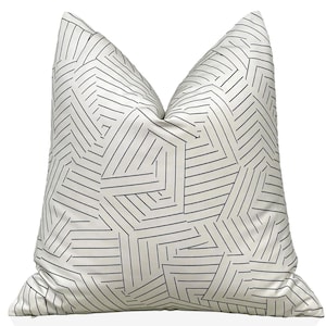 May include: White pillow with a black geometric pattern of lines and shapes.