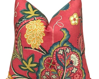 Op de afbeelding: Een roze kussen met een bloemenpatroon in tinten groen, geel, blauw en roze. Het patroon bevat paisley-vormen en gestileerde bloemen.