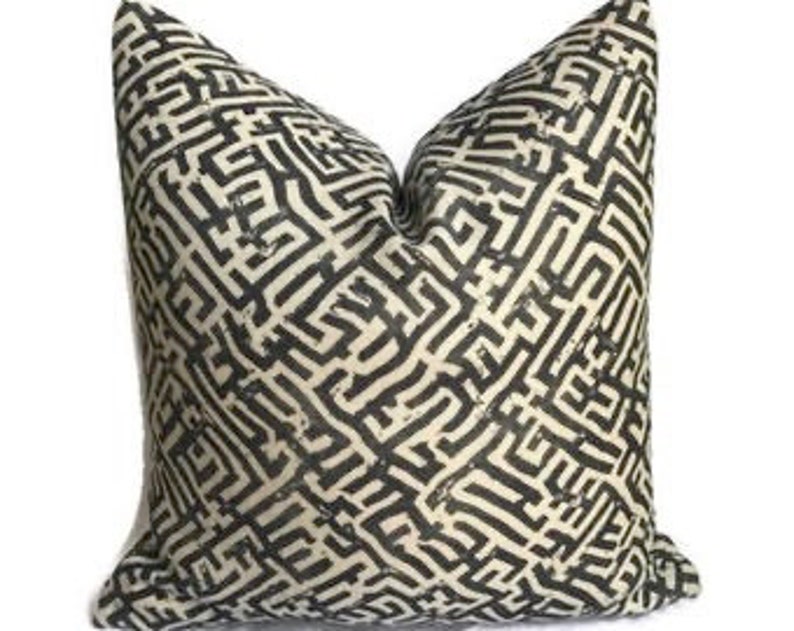 May include: Black and white geometric patterned throw pillow with a maze-like design.