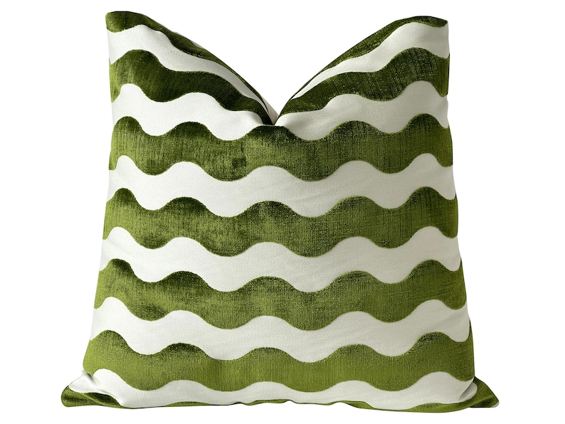 May include: A green and white pillow with a wavy pattern. The pillow is made of a soft, plush fabric and has a subtle sheen. The waves are white on a green background.