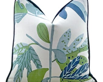 May include: A white cushion with a navy blue border and a green and blue leaf pattern.