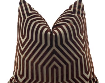 May include: A brown and cream geometric patterned throw pillow with a velvet texture.