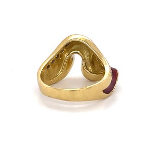 May include: A gold ring with a red enamel band and a row of small diamonds set in the band. The ring is shaped like a heart.