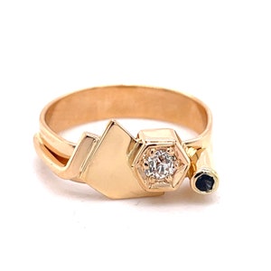 May include: Gold ring with a geometric design featuring a single diamond and a black stone.