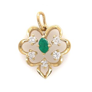 Puede incluir: Colgante de oro con dise&ntilde;o floral. El colgante presenta una esmeralda con corte marquesa en el centro, rodeada de cinco piedras preciosas redondas y claras. El colgante tiene un lazo en la parte superior para una cadena.