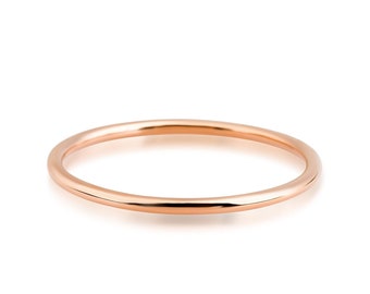 May include: A simple, thin, rose gold band ring.