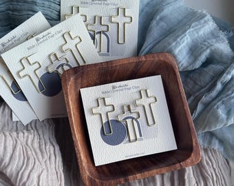 May include: A set of gold metal cross-shaped bookmark clips. The clips are packaged on cards with the text "Bible | Journal Page Clips".