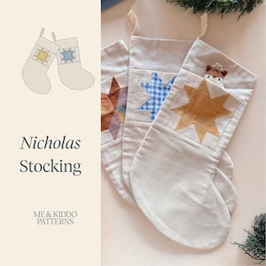 May include: Three off-white fabric stockings featuring quilted star patterns in rust, blue gingham, and mustard yellow. The right stocking contains a small plush deer head. Text on the left reads Nicholas Stocking and ME & KIDDO PATTERNS.