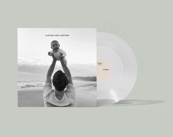 May include: A custom vinyl mixtape record with a black and white photo of a person holding a baby on a beach. The record is clear with a beige label that reads "33 RPM". The album cover reads "CUSTOM VINYL MIXTAPE".