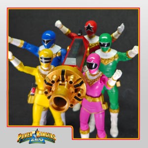 May include: Power Rangers Zeo action figures in yellow, blue, red, green, and pink. The figures are posed with arms raised, and a large golden weapon is in the foreground. The Power Rangers Zeo logo is at the bottom of the image.