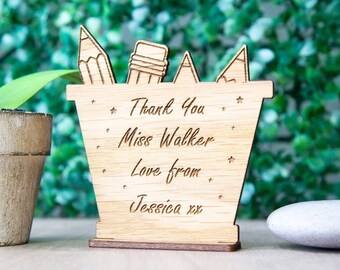 May include: A wooden pencil holder with a thank you message for Miss Walker. The holder is decorated with stars and pencils. The message reads "Thank You Miss Walker Love from Jessica xx".