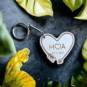May include: Wooden heart-shaped keyring with a silver key ring. The heart has the initials "H♥A" and the date "07.11.2012" engraved on it.