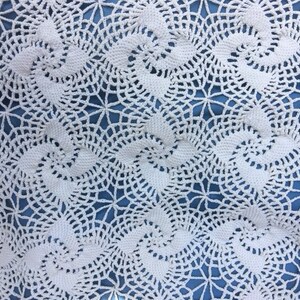 May include: White crocheted tablecloth with a delicate, intricate pattern of swirling circles and flowers.