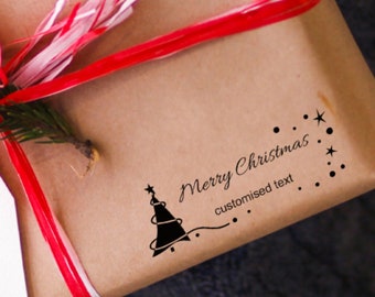 May include: A brown paper gift bag with a red and white ribbon. A black and white Christmas tree stamp with the text "Merry Christmas" and "customised text" is on the bag.