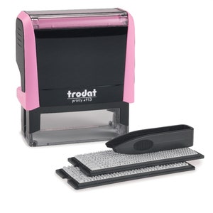 May include: A pink and black self-inking stamp with the text "trodat printy 4913" on the front. The stamp comes with a black plastic case and two replacement ink pads.