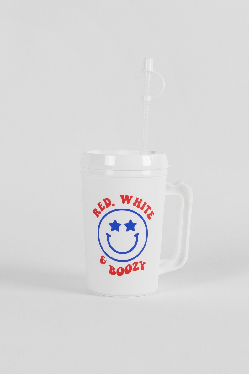 May include: White plastic cup with a red, white, and blue smiley face design. The cup has a handle and says "Red, White & Boozy".