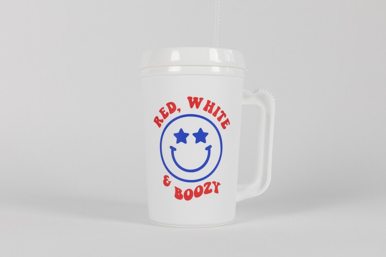 May include: White plastic cup with a red, white, and blue design. The cup has a handle and says "Red, White & Boozy" with a smiley face with stars for eyes.