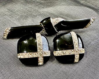 May include: A vintage jewelry set featuring a black enamel brooch and matching earrings. The brooch has a bow design, and the earrings are round. All pieces are accented with sparkling rhinestones, creating a classic and elegant look.
