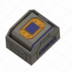 Könnte beinhalten: Eine graue, geometrische Box mit einem gold-blauen Deckel. Der Deckel hat eine rechteckige blaue Mitte mit goldenem Rand. Die Box hat ein futuristisches, industrielles Design mit rechteckigen Fenstern an der Seite.