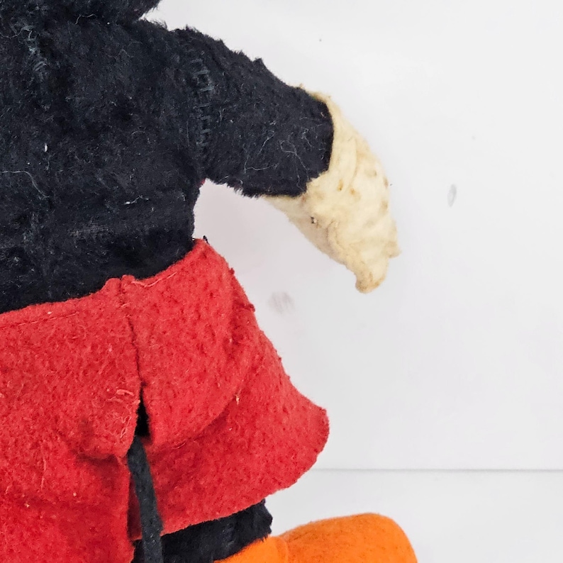 May include: Vintage plush Mickey Mouse toy with black fur, red shorts, and white gloves. The toy is in good condition, but shows signs of wear.