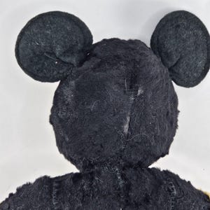 May include: Black plush toy with large ears shaped like Mickey Mouse's ears.