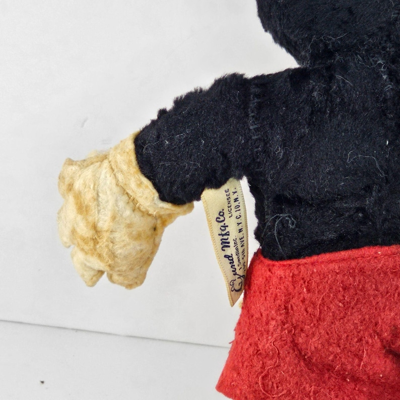 May include: Vintage plush Mickey Mouse toy with black fur, red shorts, and a white glove. The toy has a tag that reads "Genuine, Licensed,  Good  Mfg. Co., 1290 Ave.  N.Y.C. 10, N.Y."