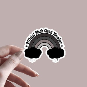 May include: A 3.0" x 2.5" sticker featuring a black and grey rainbow with the text "Official Black Cloud Member" in black.