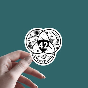 May include: A black and white sticker with a Venn diagram showing the intersection of life, the universe, and everything. The number 42 is in the center of the diagram. The sticker is 2.5 inches by 2.5 inches.