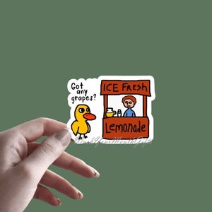 May include: A yellow duck cartoon sticker with the text "Got any grapes?" next to a cartoon sticker of a lemonade stand with the text "ICE FRESH Lemonade".