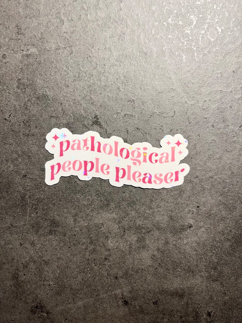 Pode incluir: Adesivo rosa e branco com o texto "pathological people pleaser" com detalhes de glitter.