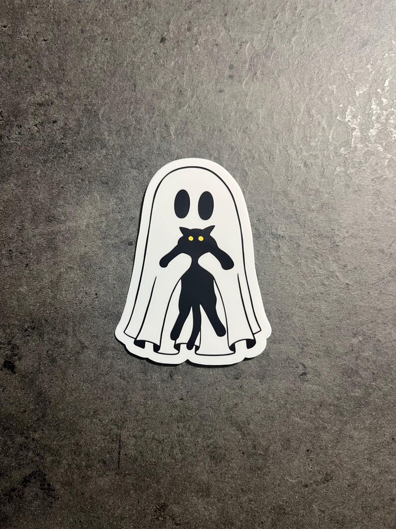 May include: A white ghost sticker with a black cat silhouette inside. The cat has yellow eyes and is peeking out from behind the ghost.